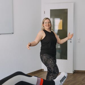 Eine Hebamme macht Übungen in einem Rückbildungskurs.