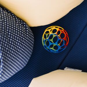 Ein Baby-Spielzeugball ligt auf dem Boden zwischen Stillkissen.